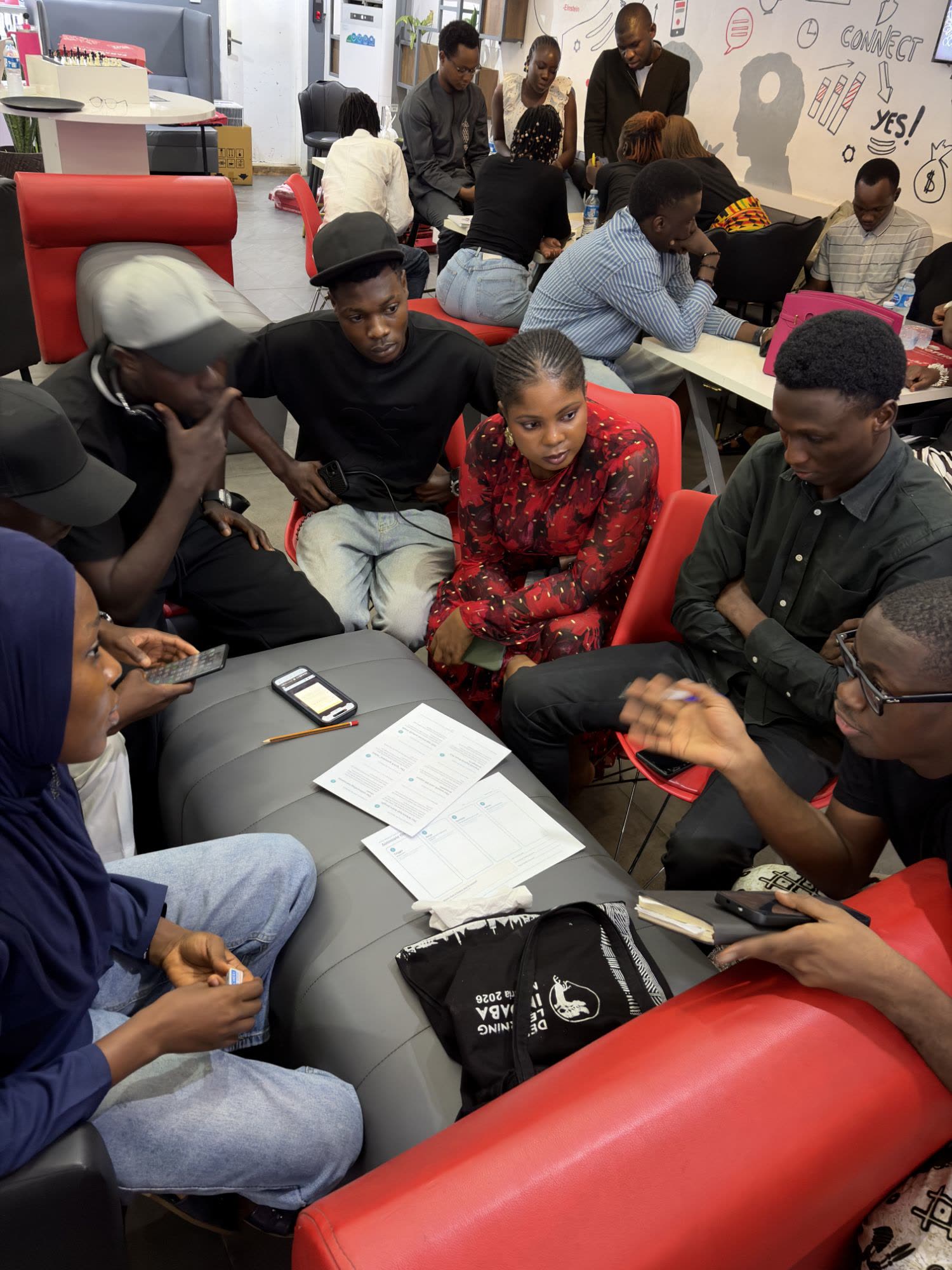 Workshop participants around a low table with the case cards, design canvas and a phone